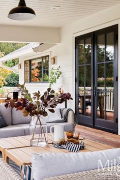 a living room filled with furniture and a wooden table on top of a hard wood floor