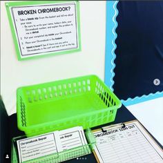 a green basket sitting on top of a table next to a binder and papers