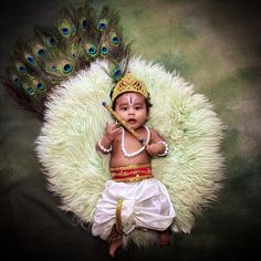 a baby dressed up as a peacock with feathers