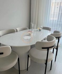 a white table with six chairs around it