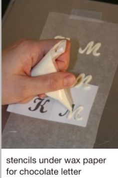 someone is cutting out the letters with a pair of scissors on top of a piece of paper