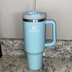 a blue travel mug sitting on top of a counter