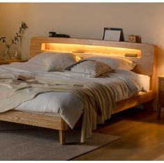 a bed that is made up with pillows and blankets on top of it, next to a night stand