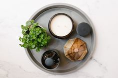 a tray with candles, rocks and a potted plant sitting on top of it