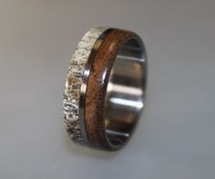 a wedding ring with wood and antler inlays on the inside of it