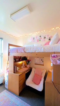 a bedroom with bunk beds and desks in the corner, lights strung above it