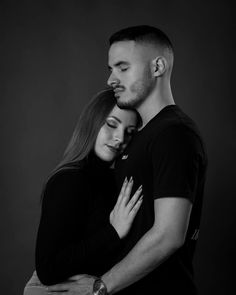 a man and woman embracing each other in black and white with their arms around one another