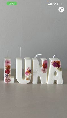 the word luma spelled out with flowers in front of a white wall and grey background