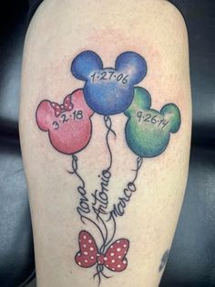 mickey mouse tattoo with three balloons and the date disney world on it's thigh