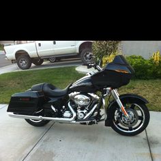 a black motorcycle parked in front of a white truck