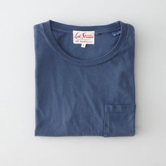 a blue t - shirt with a white tag on it's chest and pocket