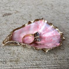 a pink shell with two wedding rings in it