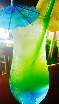 a blue and green drink with an umbrella