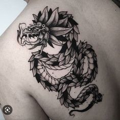 a black and white photo of a dragon tattoo on the back of a woman's shoulder