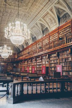 an old library with chandeliers and bookshelves filled with lots of books