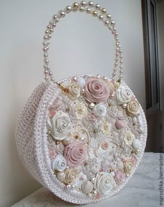 a white purse with flowers and pearls on it