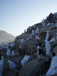 a group of men standing on top of a rocky hillside