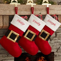 christmas stockings hanging from a mantel over a fire place