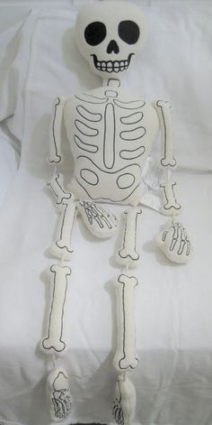 a stuffed skeleton sitting on top of a bed