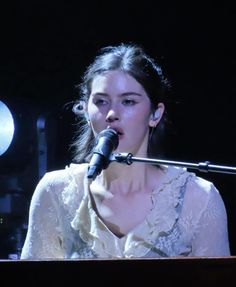 a woman is singing into a microphone