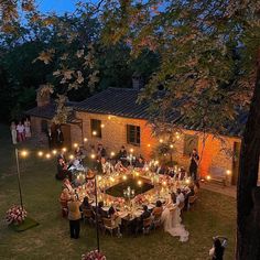 an aerial view of a wedding reception in the backyard at night with candles lit up