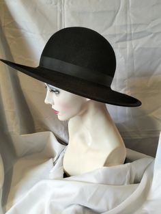 Perfect, black, wool felt, wide brimmed hat , the brim is properly wired and covered with black French millinery petersham which matches the hat band. The inside is finished with hand sewn petersham ribbon. It is made for a 22 inch head but can be stretched slightly (please let me know if you need this service). It can also be sprayed with water resisting spray again please let me know if you need this service.  If the hat is shipped out of the UK we roll the side brims in for shipping otherwise Classic Black Wide Brim Costume Hat, Kentucky Derby Wide Brim Fur Felt Top Hat, Classic Black Fedora Costume Hat, Classic Fedora Costume Hat For Formal Events, Classic Formal Fedora Costume Hat, Black Wool Top Hat With Curved Brim, Formal Black Wool Hat, Black Fur Felt Hat With Curved Brim, Black Felt Hat With Curved Brim