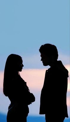 two people standing next to each other in silhouette