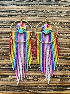 These are a show stopper! Bright rainbow colored beauties with a pop of gold.  These are made with matte finished glass beads, brass hoop, stainless steel ear wire, metal enamel flower charm. Bohemian Rainbow Beaded Round Earrings, Bohemian Rainbow Round Beaded Earrings, Rainbow Beaded Dangle Hoop Earrings, Rainbow Dangle Earrings With Tiny Beads, Rainbow Beaded Earrings With Tiny Beads For Festivals, Rainbow Round Earrings With Colorful Beads, Adjustable Rainbow Earrings With Tiny Beads, Multicolor Beaded Flower Earrings For Festivals, Multicolor Beaded Round Earrings For Festivals