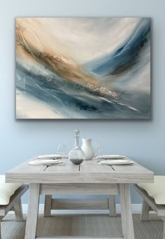 a painting on the wall above a dining room table with white chairs and place settings