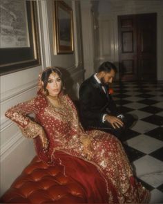 a man sitting next to a woman in a red dress