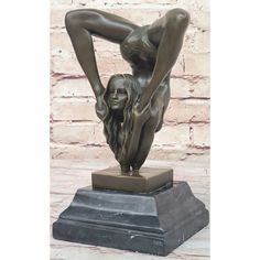 a bronze statue of a woman bending over with her hands behind her head, on a pedestal