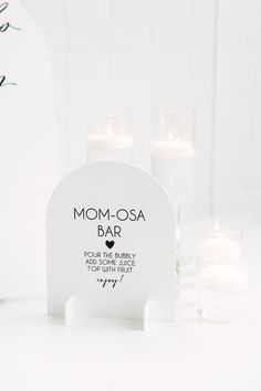 a white memorial with candles in front of it and the words mom - osa bar written on it