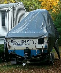 a boat covered with a tarp in front of a house