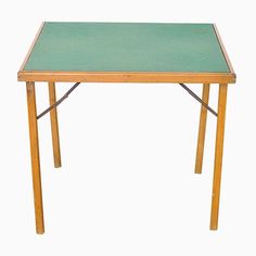 a small wooden table with a green top on a white background in the shape of a square