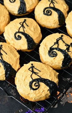 halloween cookies decorated with black icing on a cooling rack