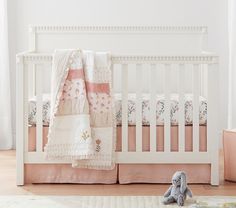 a baby crib with a stuffed animal next to it and the words pottery barn kids