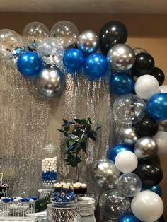 a table topped with lots of balloons and cake