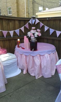 a table with pink and white cloths on it is set up for a party