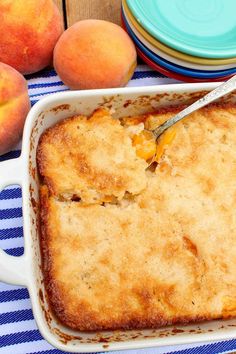 a casserole dish with peaches next to it on a blue and white table cloth