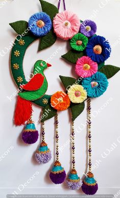 an ornament with flowers and birds hanging from it's sides on a wall