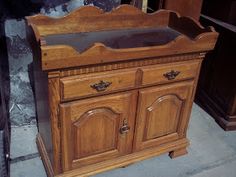 an old wooden cabinet sitting on the ground