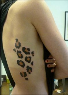 the back of a woman's body with leopard print on her left arm and chest