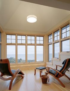 a living room filled with furniture and large windows