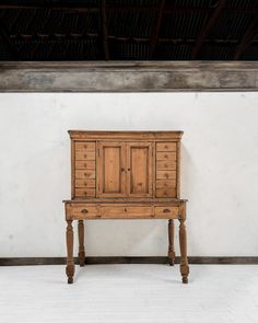 an old wooden dresser sitting on top of a white floor