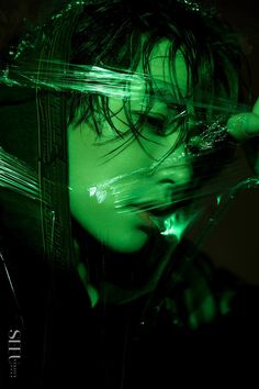 a woman with dark hair and green lights