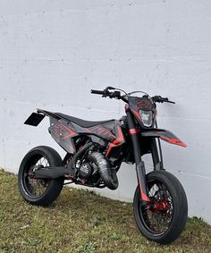 a dirt bike parked next to a white wall