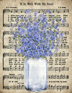 blue flowers in a mason jar with sheet music