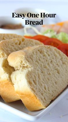 a white plate topped with slices of bread next to a tomato and lettuce