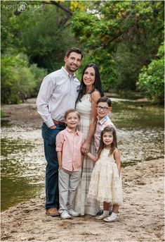 a family posing for a photo in front of a river