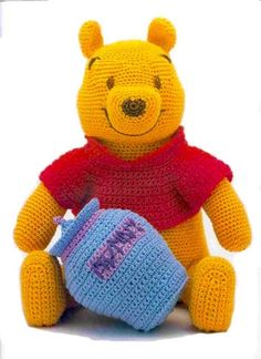 a crocheted winnie the pooh stuffed animal with a knitted tea pot